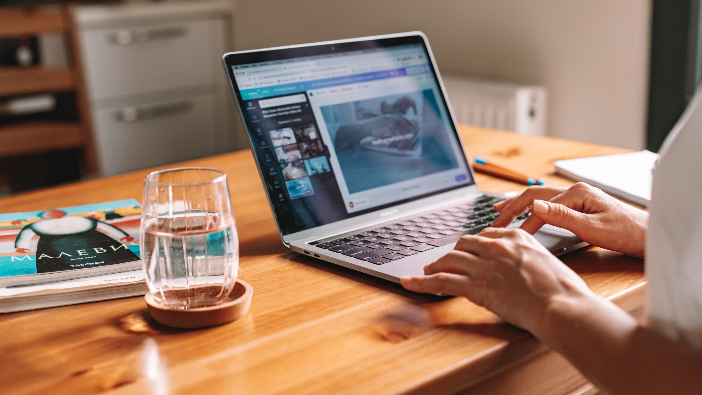 Laptop on table with person working remotely